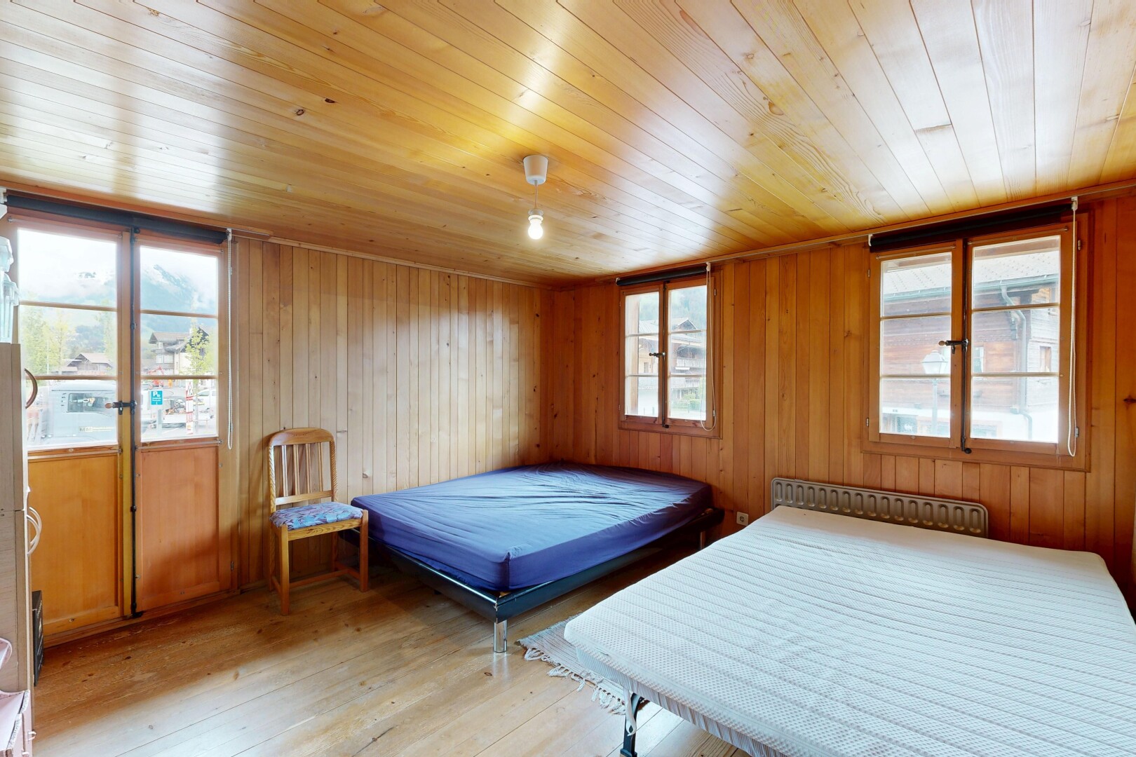 zimmer / schlafzimmer mit holzfußboden, wood finish floor, holzwand, wood wall, und inside property
