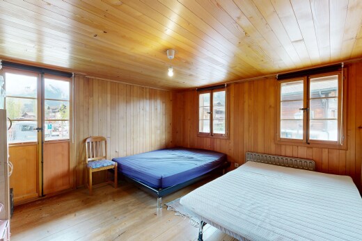 zimmer / schlafzimmer mit holzfußboden, wood finish floor, holzwand, wood wall, und inside property