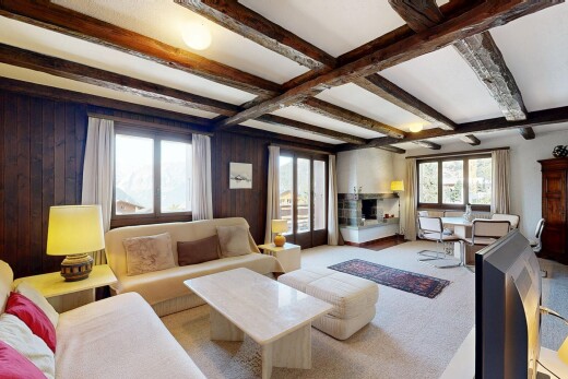 salon avec beamed ceiling, plafond à poutres, wood wall, mur en bois, et high end ceiling