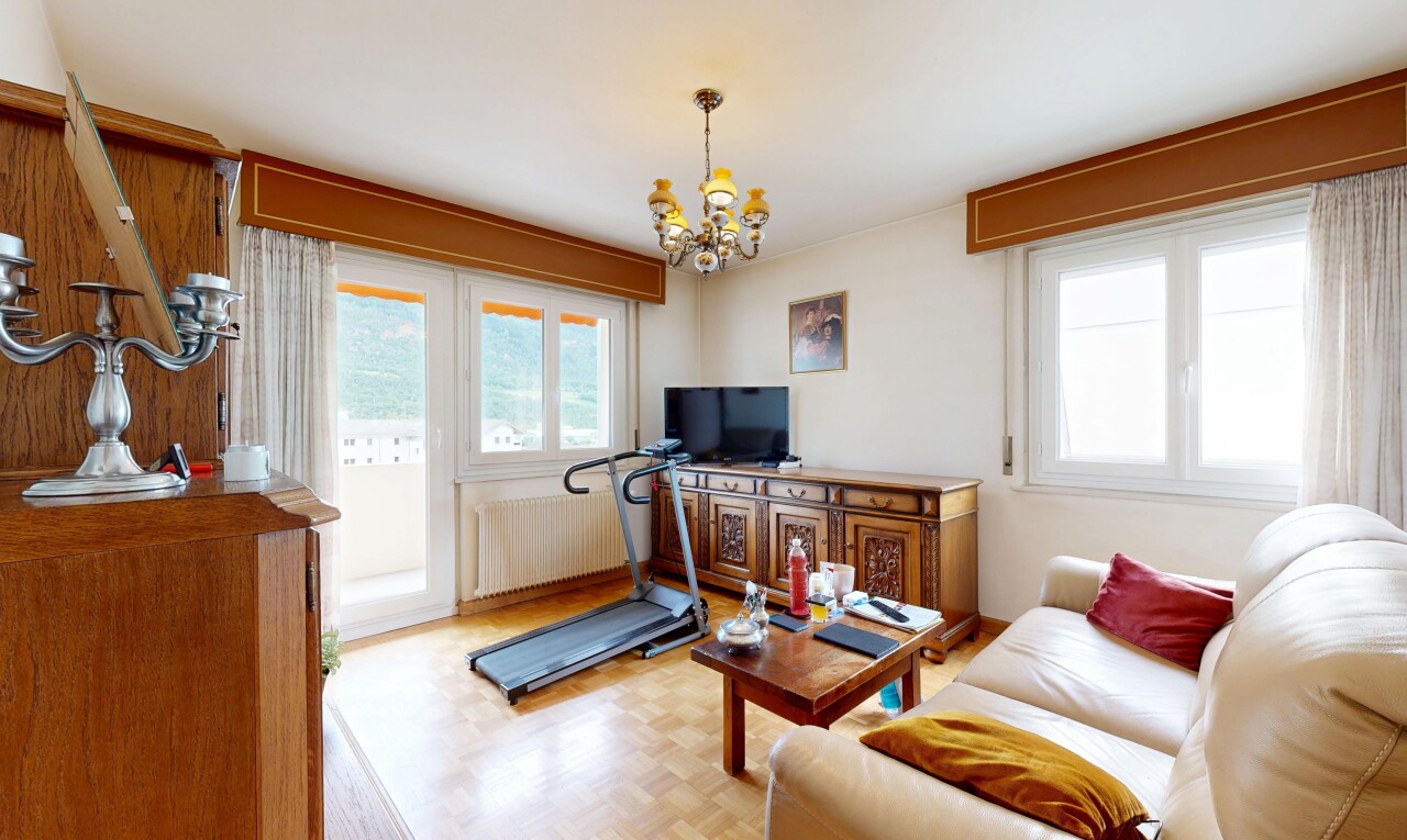 living area featuring parquet floors, suspended lighting, and radiator