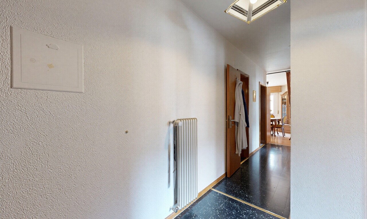 corridor with radiator and a textured wall