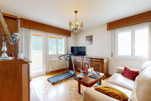 living area featuring parquet floors, suspended lighting, and radiator