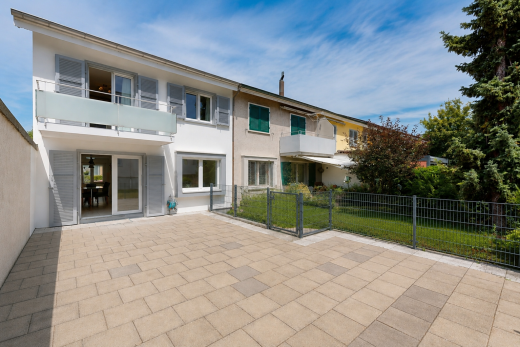 view of property with a balcony, stucco siding, a gate, and a patio area