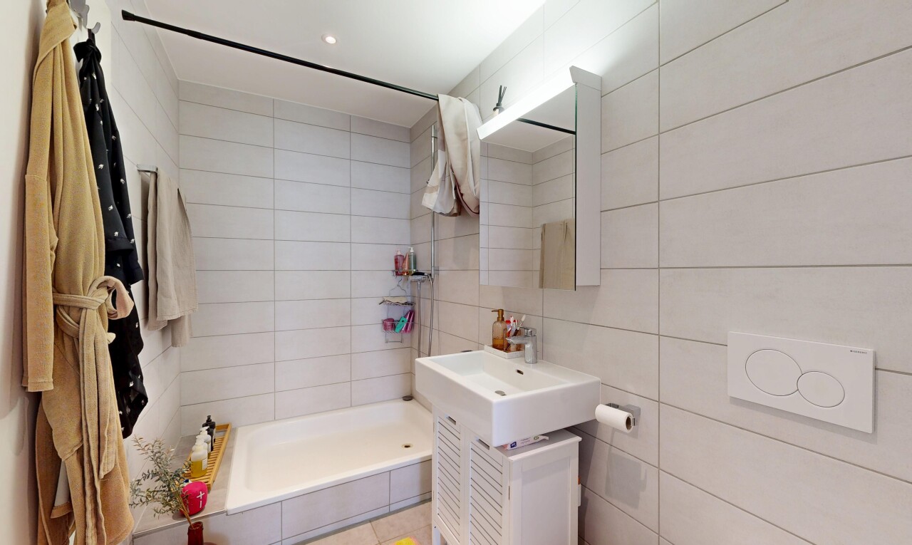 salle de bains avec mur en carrelage, tile wall, salle de bain complète, douche, et miroir