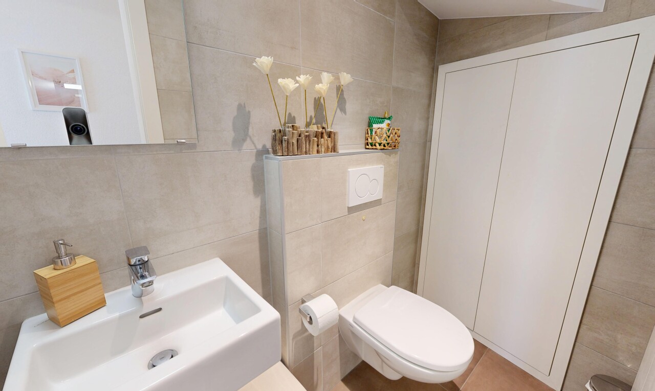 salle de bains avec mur en carrelage, tile wall, évier, inside property, et toilette