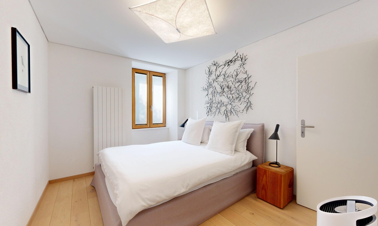 chambre avec radiateur, cloison sèche, drywall, sol en finition bois, et wood finish floor