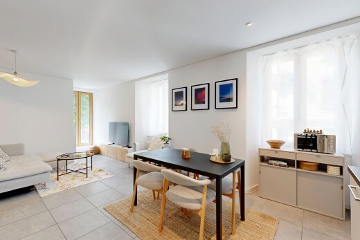 salon / salle à manger avec cloison sèche, drywall, lumière naturelle, télévision, et éclairage suspendu