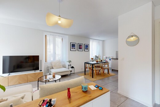 salon / salle à manger avec télévision, light floor, cloison sèche, drywall, et lumière naturelle