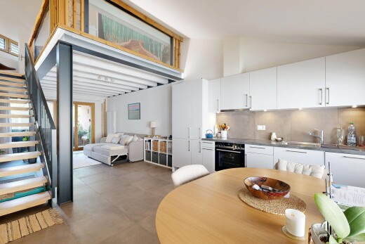 cuisine avec escaliers, white cabinets, armoires blanches, four, et vaulted ceiling