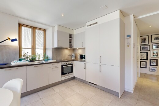 cuisine avec plans de travail, dark countertops, light floor, four, et armoires blanches