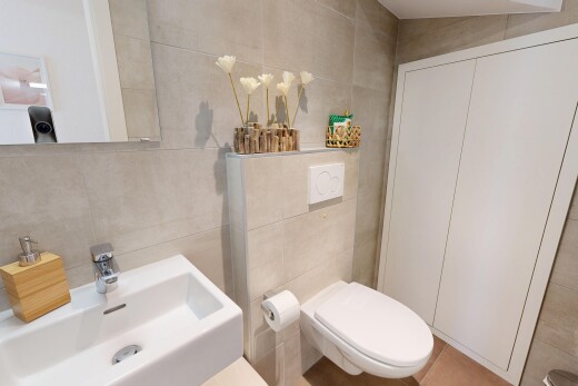 salle de bains avec mur en carrelage, tile wall, évier, inside property, et toilette