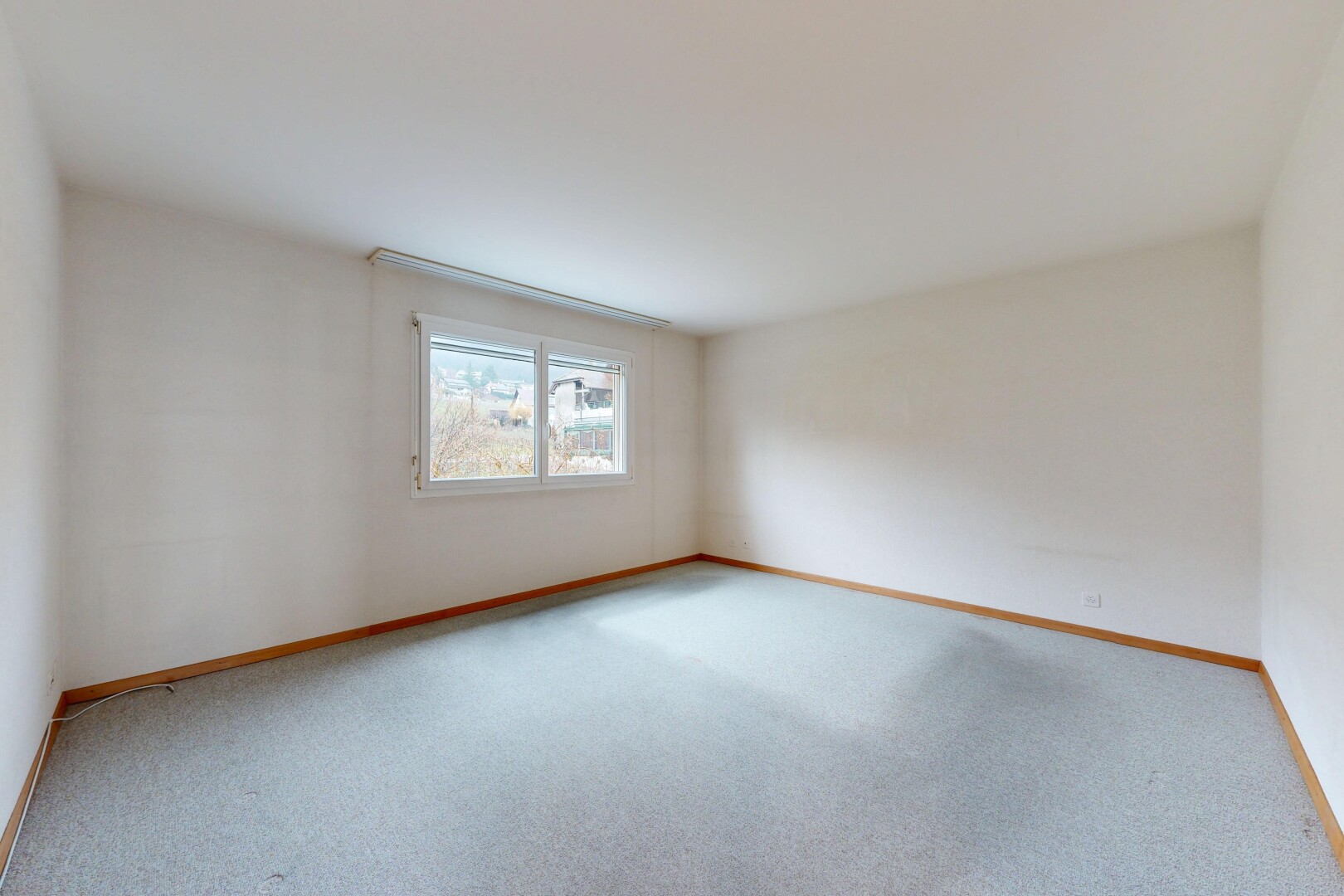 carpeted spare room featuring baseboards