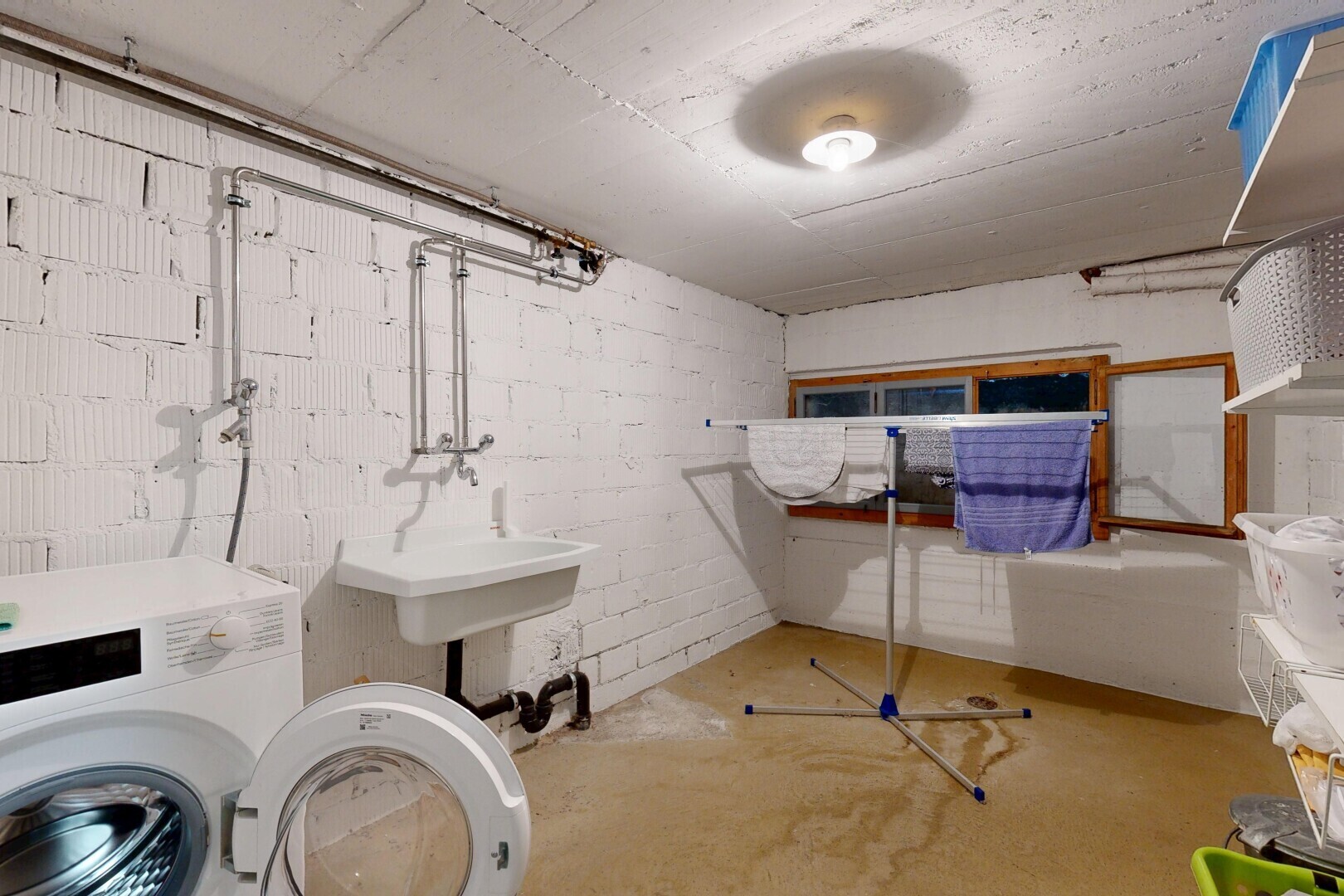 buanderie avec lave-linge et sèche-linge, inside property, concrete floor, sol en béton, et évier