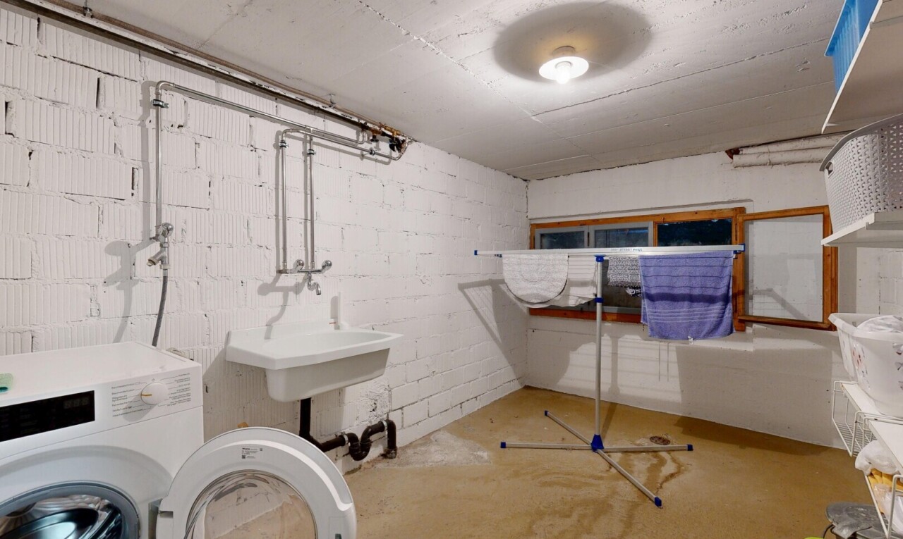 buanderie avec lave-linge et sèche-linge, inside property, concrete floor, sol en béton, et évier