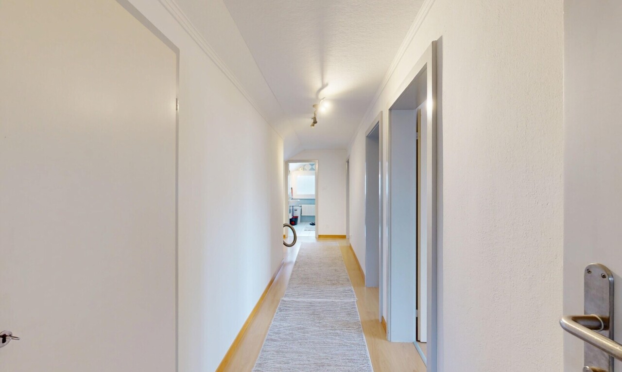 couloir avec inside property, light floor, wood finish floor, sol en finition bois, et drywall