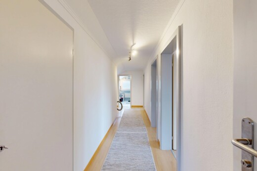 couloir avec inside property, light floor, wood finish floor, sol en finition bois, et drywall