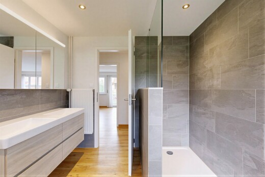 salle de bains avec douche, salle de bain complète, lavabo (ou coiffeuse selon le contexte), sol en finition bois, et wood finish floor