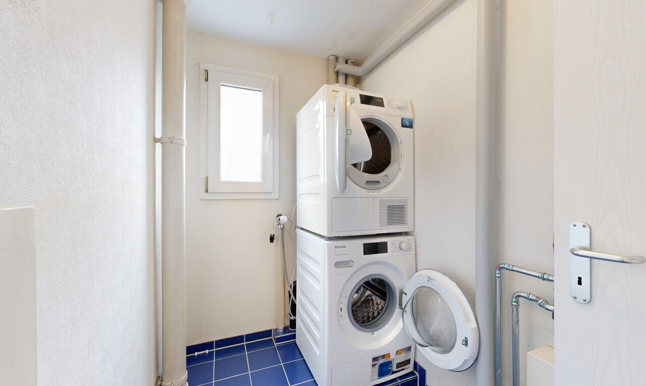 wäschekammer mit inside property, waschturm, natural light, natürliches licht, und dark floor