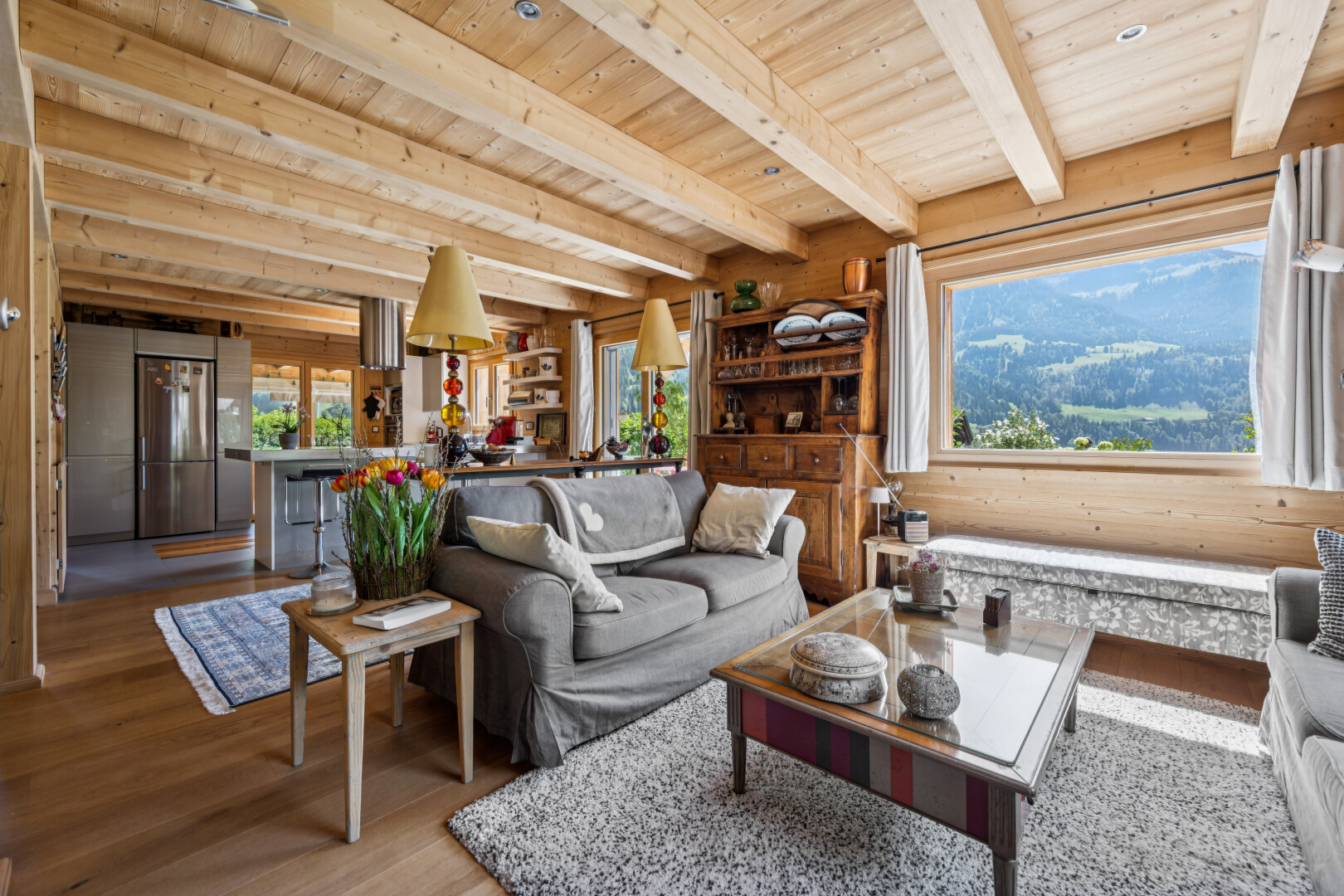 living room with a wooden ceiling with exposed beams, wood finished floors, and a mountain view