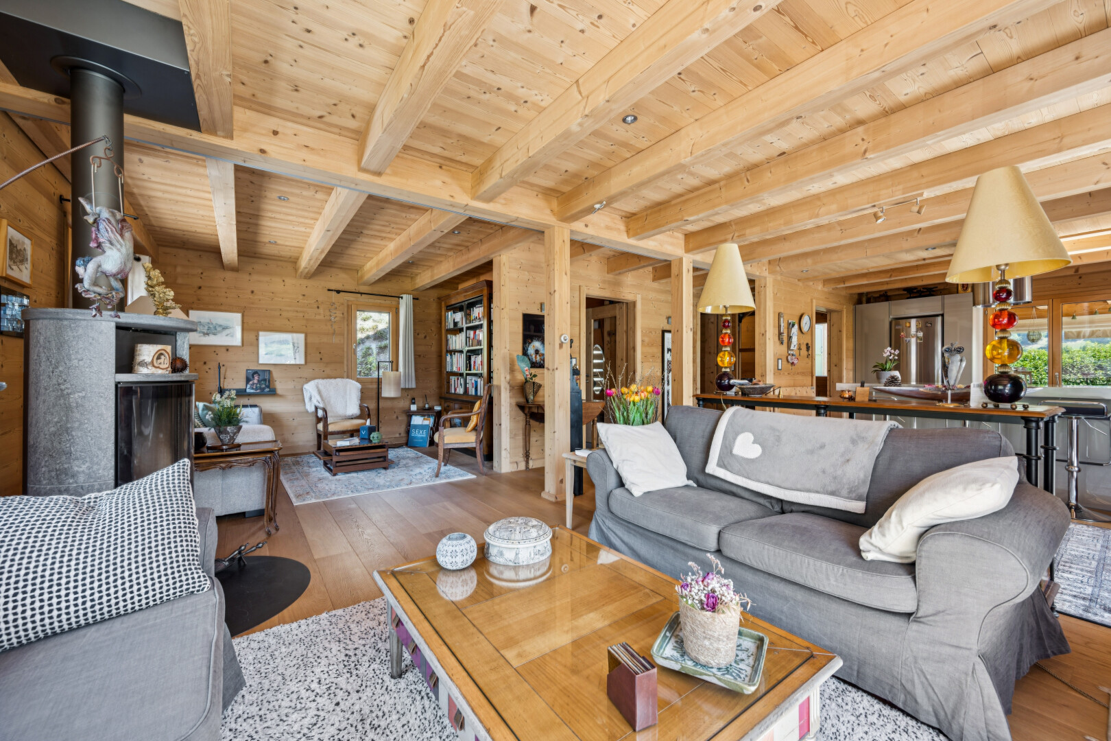 living area with wood-type flooring, a wooden ceiling with exposed beams, wood walls, and rail lighting