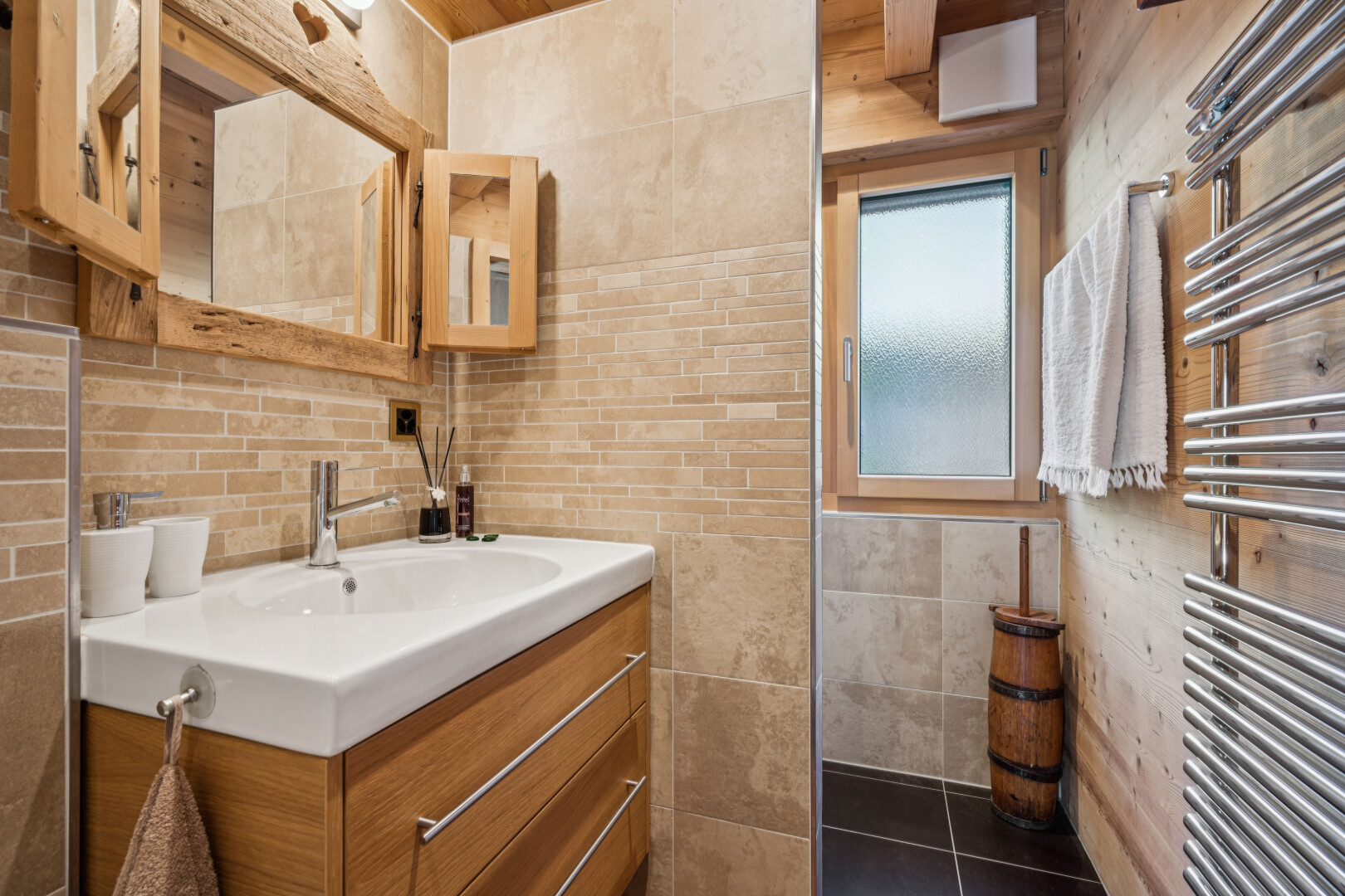 bathroom featuring a towel warmer, radiator, vanity, tile walls, and dark tile patterned flooring
