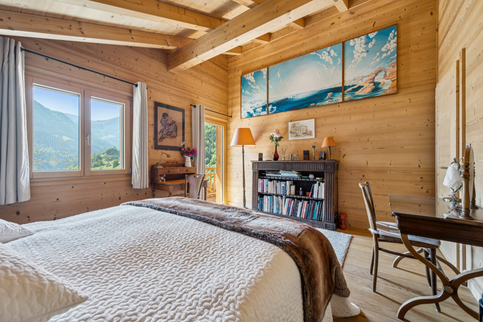 room with wood walls, lofted ceiling with beams, light wood-type flooring, and a mountain view
