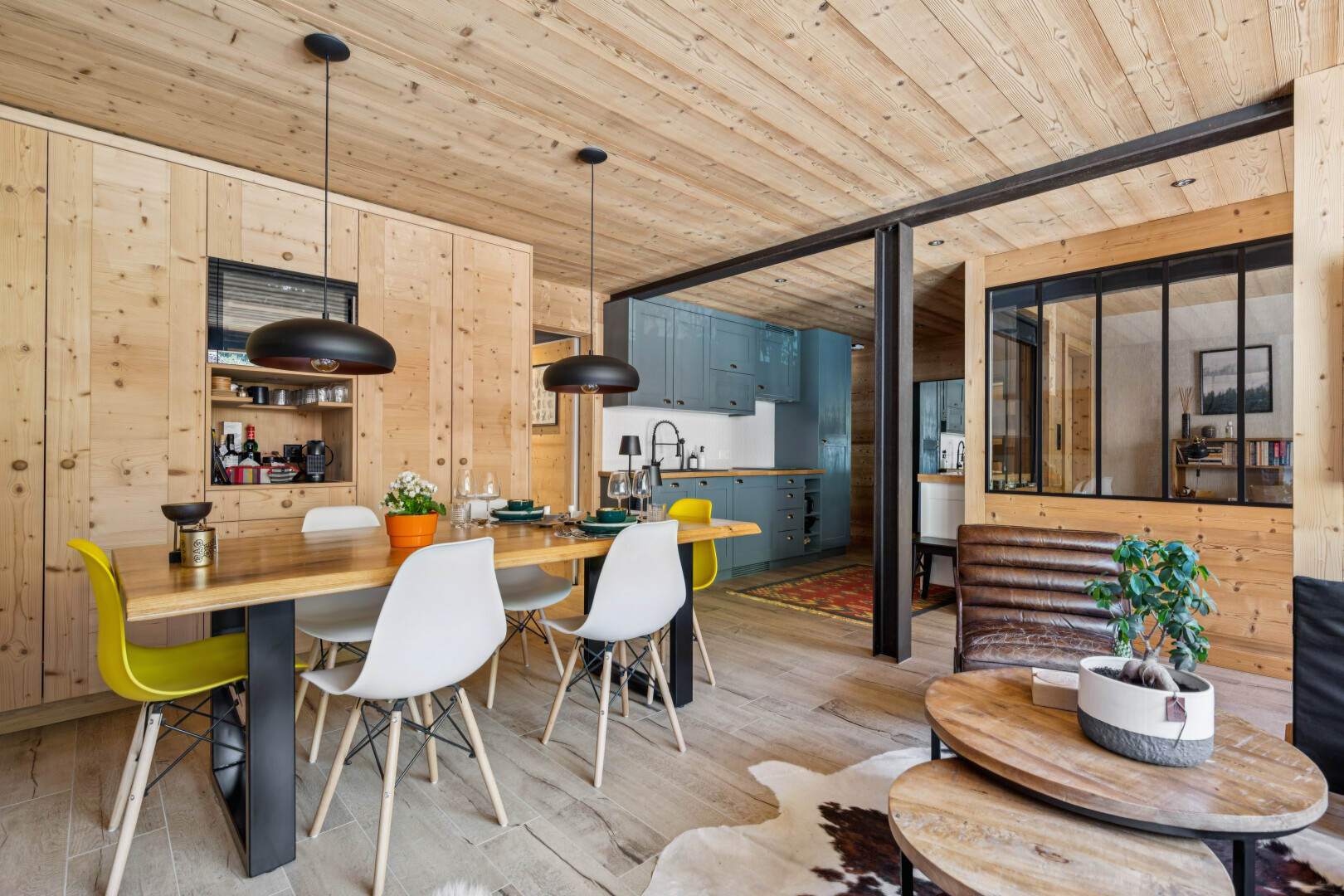 dining space with decorative light fixtures, wooden walls, wood ceiling, and light wood-style floors