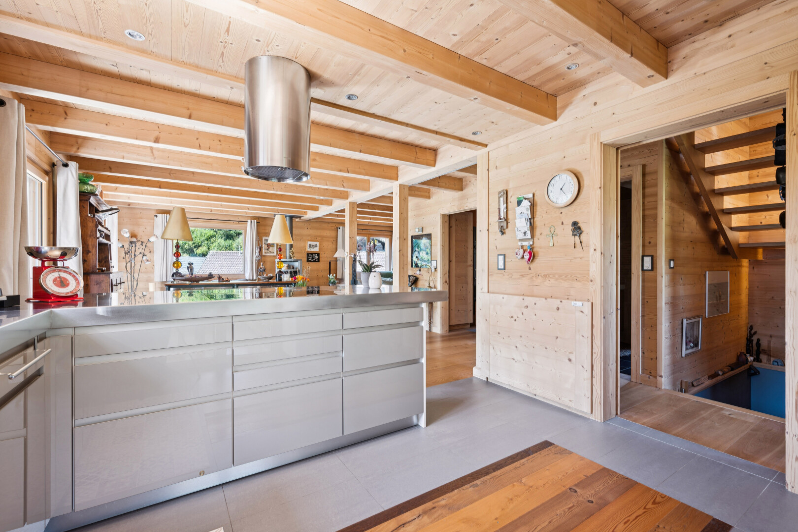 kitchen featuring a wooden ceiling with exposed beams, wood walls, stainless steel counters, and a peninsula