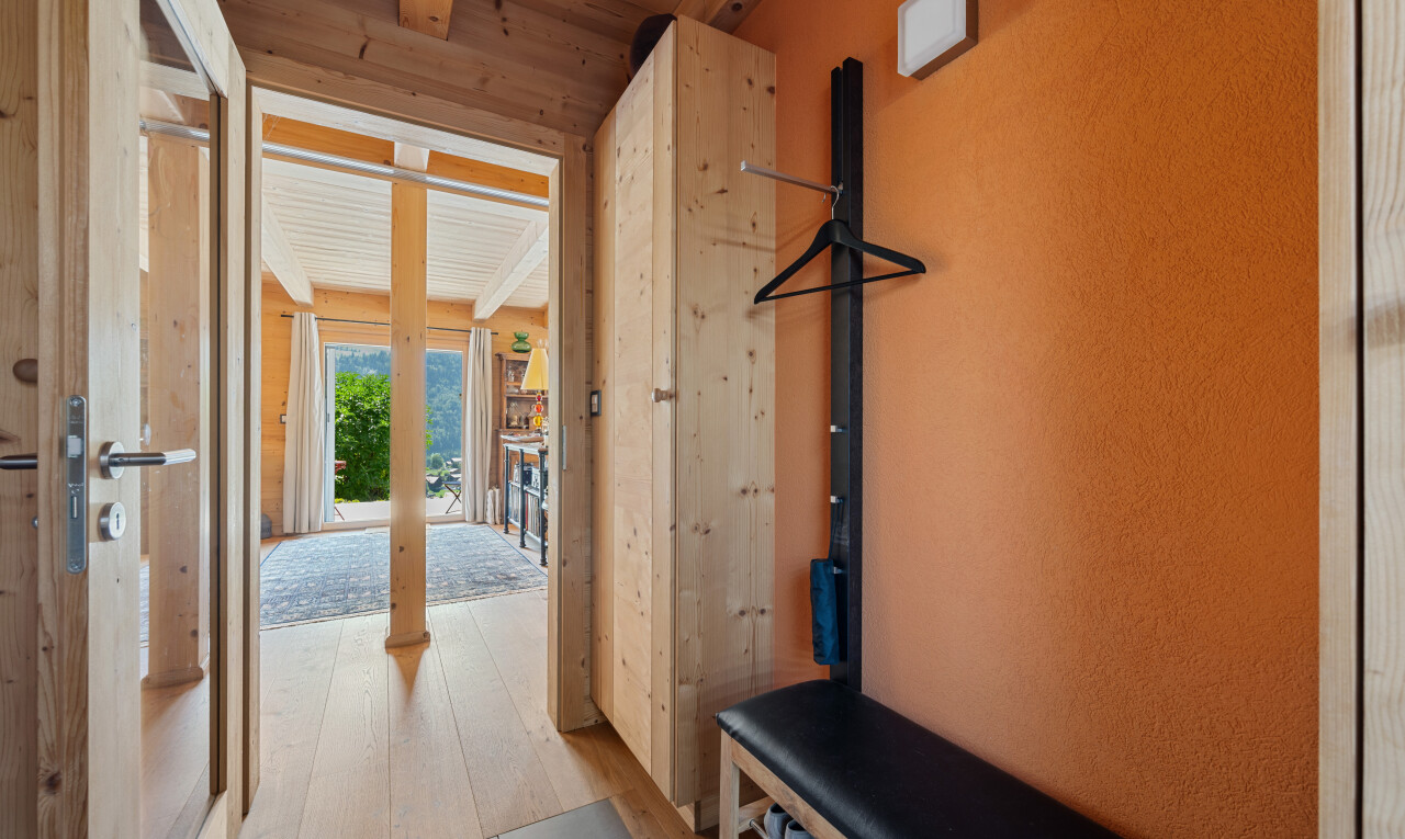 hall featuring a wood ceiling with exposed beams and light wood finished floors