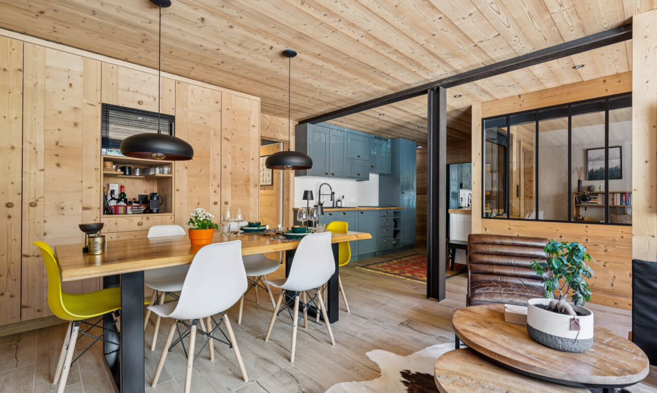 dining space with decorative light fixtures, wooden walls, wood ceiling, and light wood-style floors