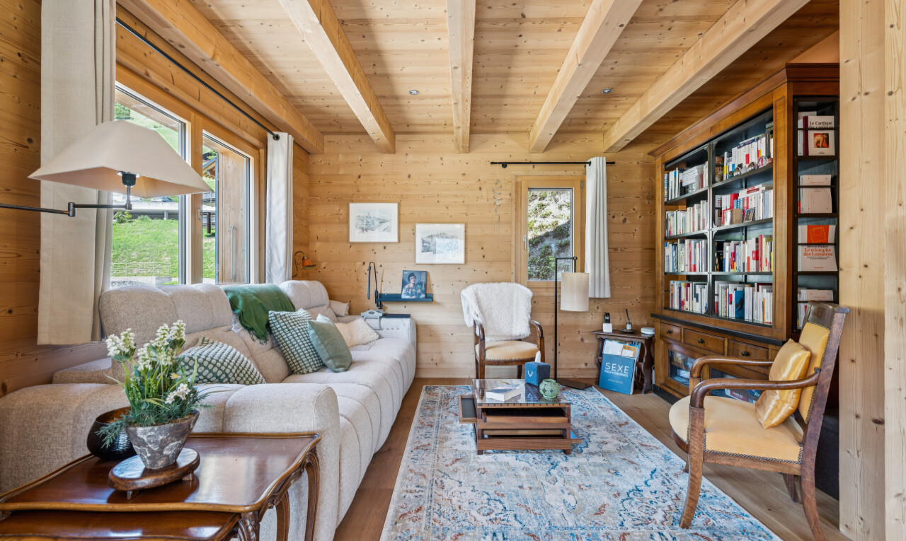 living area featuring built in features, wooden walls, a wood ceiling with exposed beams, wood finished floors, and healthy amount of natural light