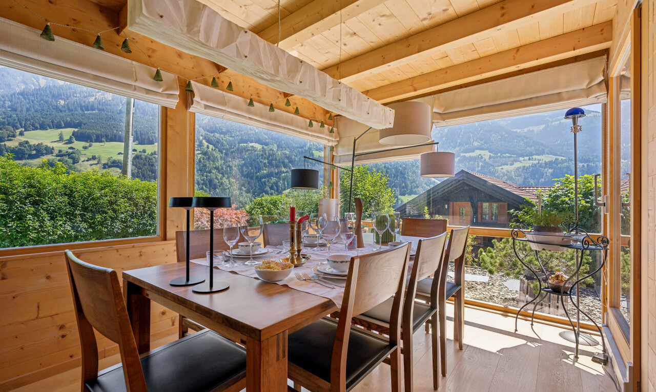 dining room featuring a wood ceiling with exposed beams, light wood finished floors, wooden walls, and a mountain view