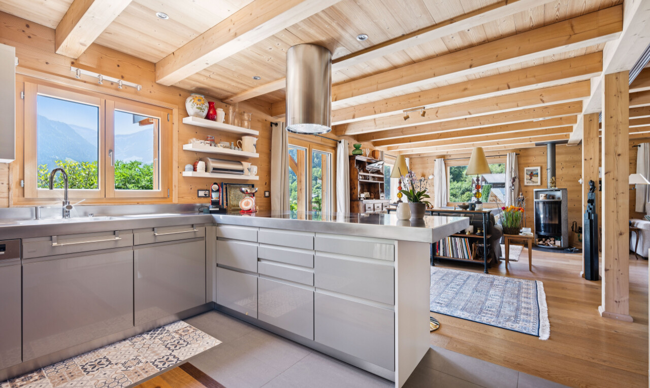 cuisine avec stainless steel countertops, plans de travail en acier inoxydable, plafond à poutres, beamed ceiling, et plafond en bois