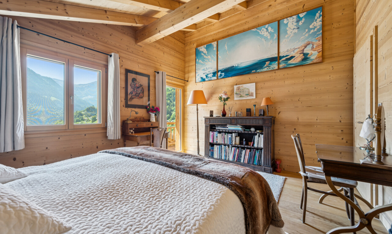 room with wood walls, lofted ceiling with beams, light wood-type flooring, and a mountain view