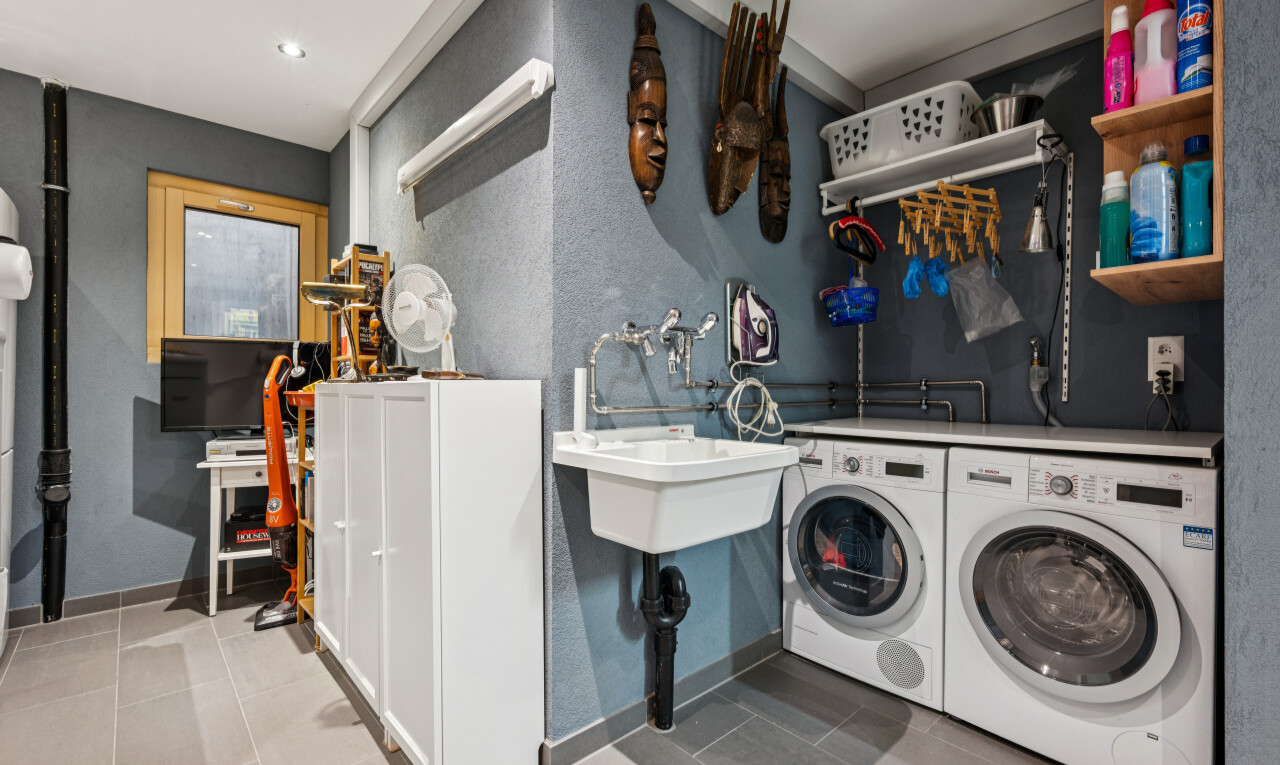 buanderie avec évier, éclairage encastré, télévision, lave-linge et sèche-linge séparés, et plinthes murales