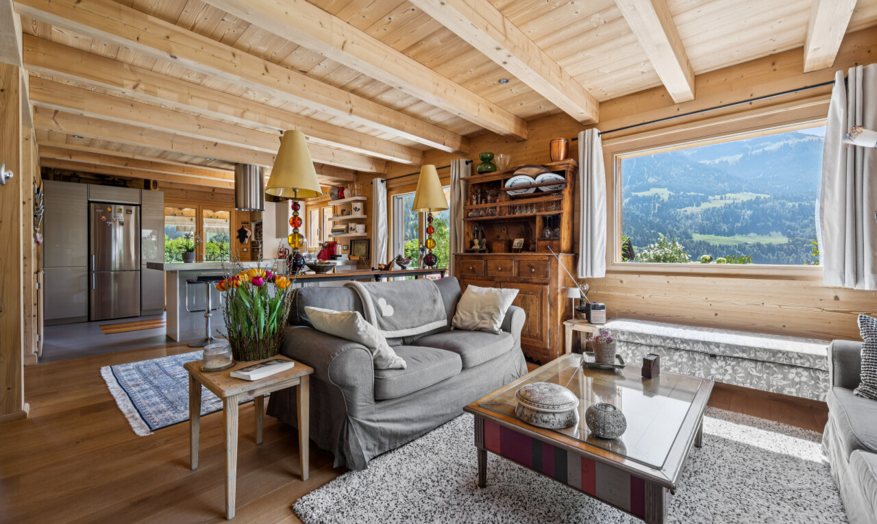 living room with a wooden ceiling with exposed beams, wood finished floors, and a mountain view