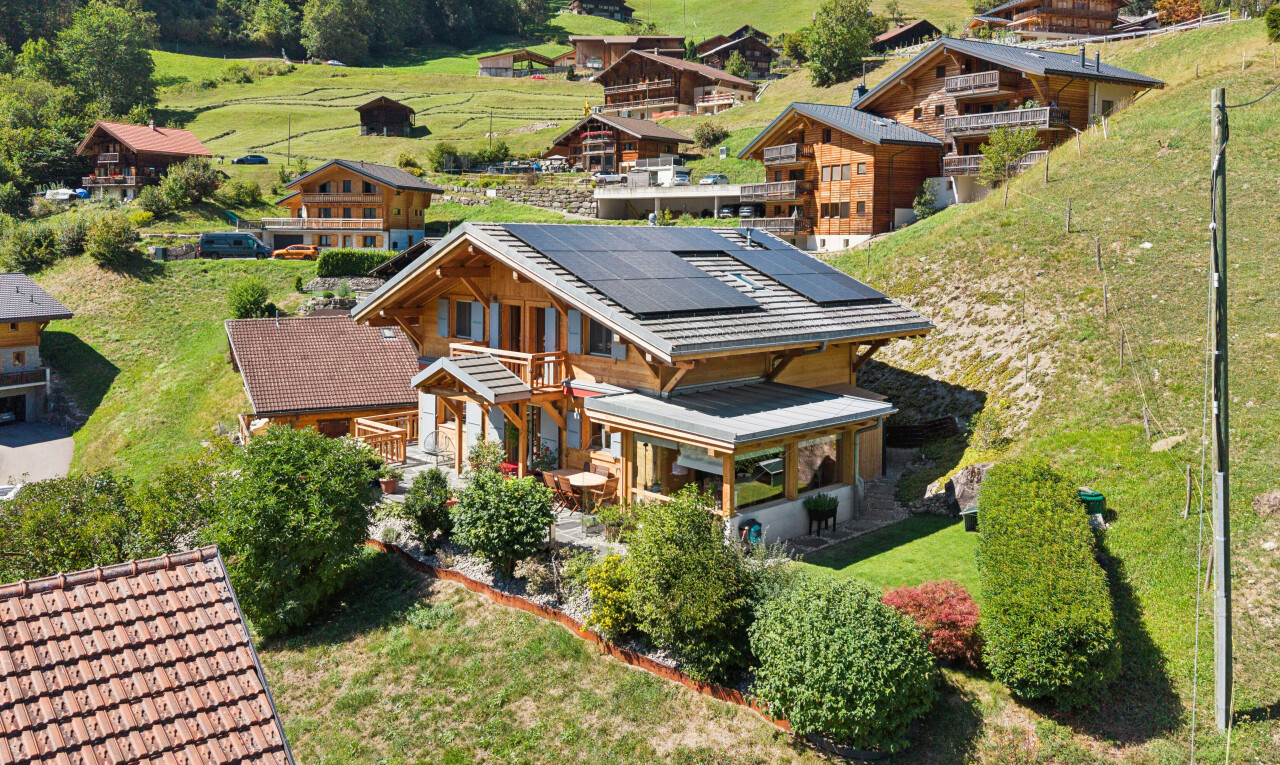 façade avec panneaux solaires, property visible, porche, drone view, et pelouse