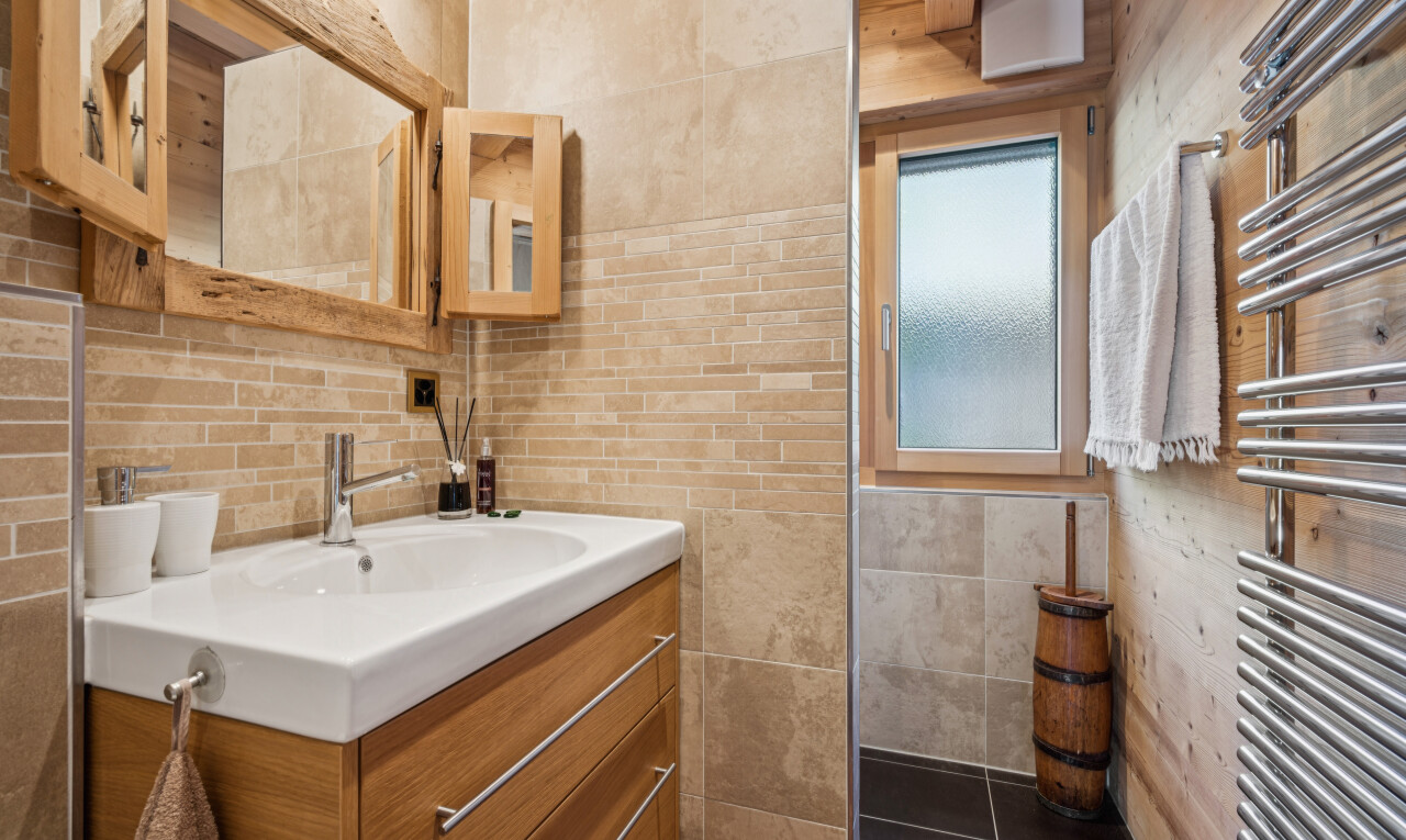 salle de bains avec chauffe-serviettes, miroir, radiateur, lavabo (ou coiffeuse selon le contexte), et tile wall
