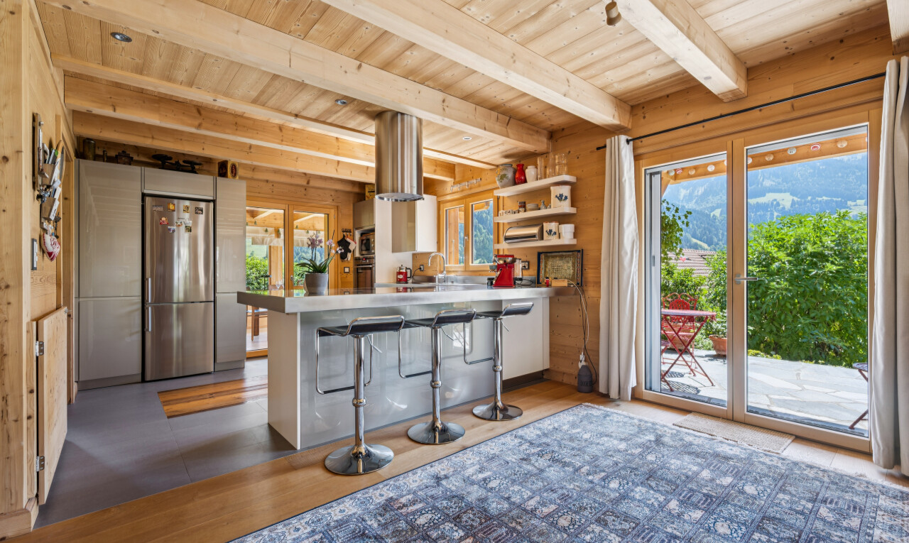 kitchen featuring a wood ceiling with exposed beams, stainless steel refrigerator, a breakfast bar, a peninsula, and open shelves
