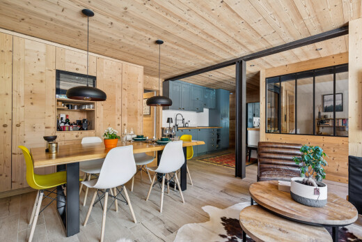 dining space with decorative light fixtures, wooden walls, wood ceiling, and light wood-style floors