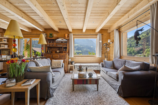 living room with a wood ceiling with exposed beams, a mountain view, and wood finished floors