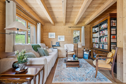 living area featuring built in features, wooden walls, a wood ceiling with exposed beams, wood finished floors, and healthy amount of natural light