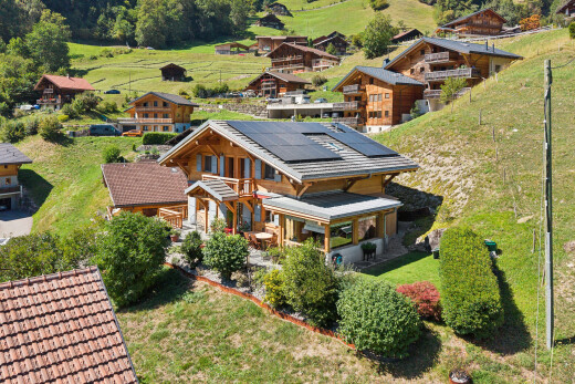 view of home with solar panels, covered porch, and a lawn