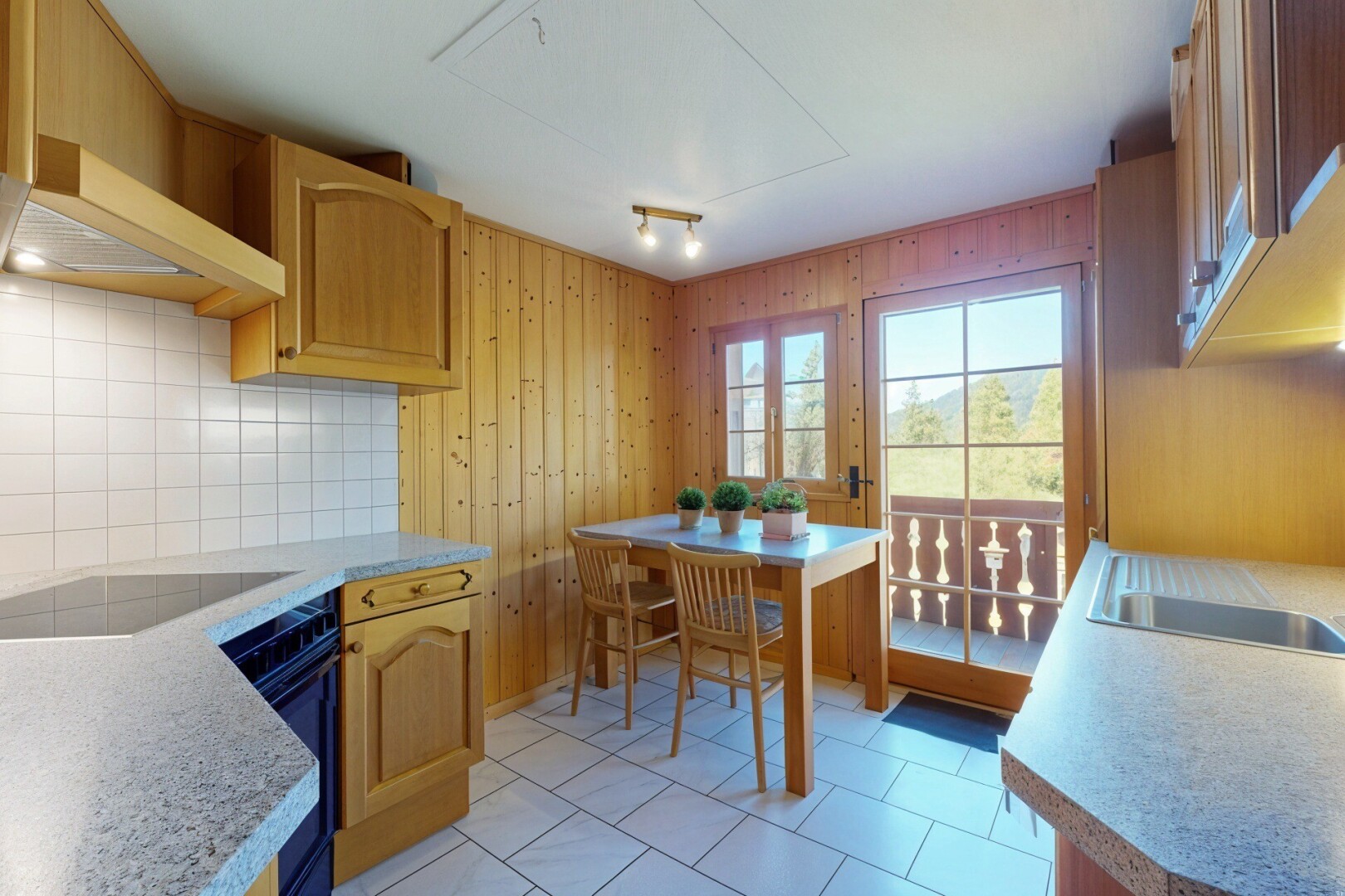 cuisine avec armoires en arc, natural light, lumière naturelle, plans de travail, et tile floor