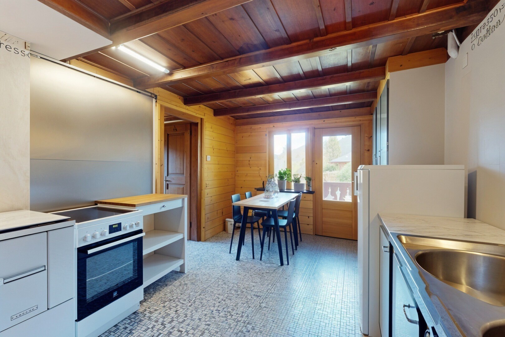 cuisine avec lumière naturelle, natural light, mur en bois, wood wall, et plafond à poutres