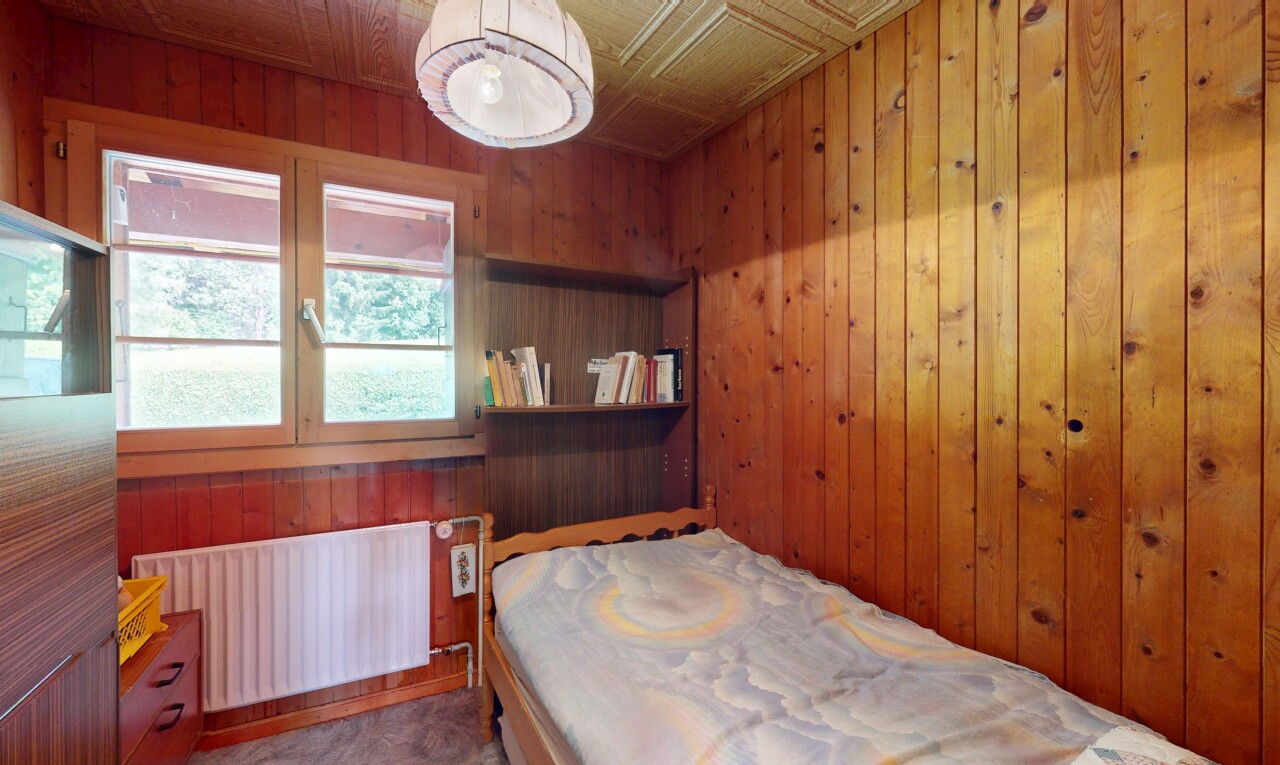 chambre avec radiateur, wood wall, mur en bois, inside property, et natural light