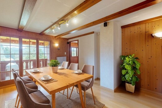 salle à manger avec wood wall, mur en bois, beamed ceiling, plafond à poutres, et wood finish floor