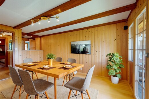 salle à manger avec wood wall, mur en bois, beamed ceiling, plafond à poutres, et wood finish floor