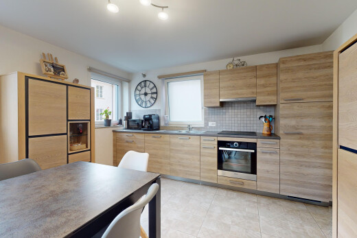 küche mit küchenrückwand beim herd, ofen, arbeitsplatten, und schränke mit flachen paneelen