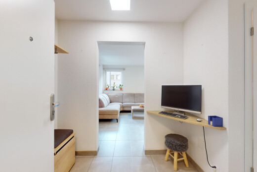 wohnzimmer mit fliesenboden, fernseher, und natürliches licht